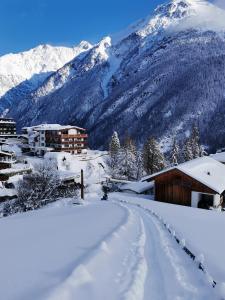 une route recouverte de neige avec des montagnes en arrière-plan dans l'établissement Haus Amaris, à Sölden