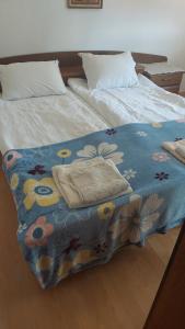 uma cama com um cobertor azul com flores em Cvrkut Ptica 1 em Mladenovac