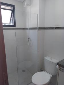 a bathroom with a toilet and a glass shower at Studio Gru in Guarulhos