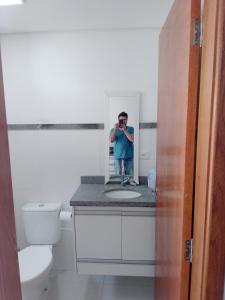 Un uomo che si fa una foto in uno specchio del bagno di Studio Gru a Guarulhos