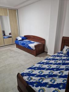 1 dormitorio con 2 camas y espejo en Appartement côté mer, en Reghaïa