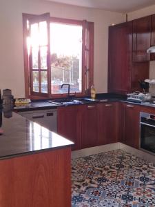 a kitchen with wooden cabinets and a window and a sink at Appartement côté mer in Reghaïa