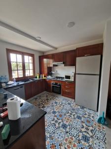 a kitchen with a white refrigerator and a tile floor at Appartement côté mer in Reghaïa