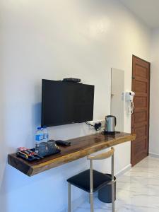 a desk with a television on a wall with a chair at Guest House Gua Kelam in Kaki Bukit