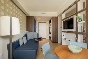 sala de estar con sofá azul y mesa en BeSUITE Apartments, en San Benedetto del Tronto