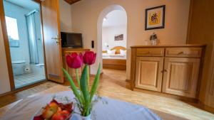 a bathroom with a vase with red tulips in it at Hotel Restaurant St. Germanshof in Bobenthal