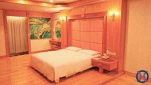 a bedroom with a large bed and a table at Hwa Du Hotel in Tainan