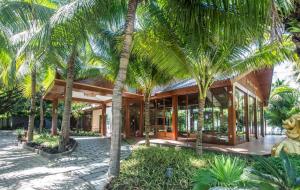 a house with palm trees in front of it at Hon Tam Resort in Nha Trang