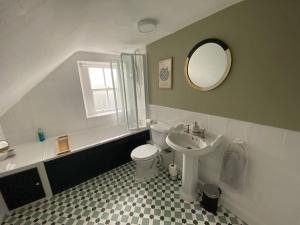 a bathroom with a sink toilet and a mirror at Knockfarrie Cottage in Pitlochry