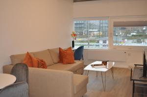 a living room with a couch and a window at Station House Apartments in Milton Keynes