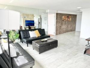 a living room with a black leather couch and a table at Waikiki Ocean View Penthouse 2/2 bdr/bath in Honolulu