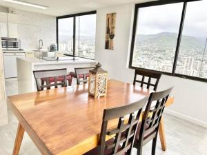 a kitchen and dining room with a wooden table and chairs at Waikiki Ocean View Penthouse 2/2 bdr/bath in Honolulu