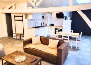 a living room with a couch and a kitchen at La Sweet House Dorée Centre Ville Wifi Tout confort in Vitry-le-François