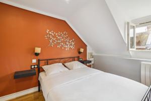 een slaapkamer met een wit bed en een oranje muur bij Chic and comfortable studio in Amiens