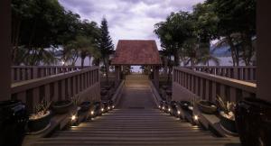 a walkway with lights and plants on a bridge at Vedana Lagoon Resort & Spa in Hue