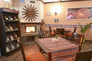 a dining room with a table and a fireplace at Hotel Ida in Bansko