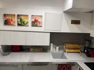 a kitchen with white cabinets and a sink at Studio entièrement équipé à 10 min de La Défense in Suresnes