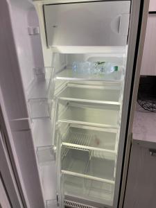 an empty refrigerator with its door open in a kitchen at Studio entièrement équipé à 10 min de La Défense in Suresnes