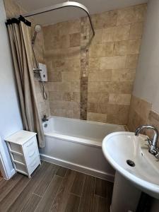 a bathroom with a white tub and a sink at Spacious Penthouse 2 bed in Birmingham