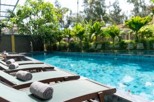 una fila de tumbonas en una piscina en CHiEM HoiAn - The Beachside Boutique Hotel & Villa en Hoi An