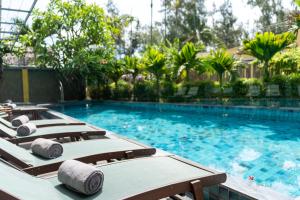 a row of lounge chairs in a swimming pool at CHiEM HoiAn - The Beachside Boutique Hotel & Villa in Hoi An