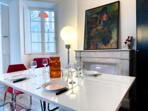 uma sala de jantar com uma mesa branca e copos de vinho em Superbe Appartement Hypercentre - L'Artistique em Pau