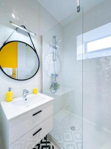 Baño blanco con lavabo y espejo en Superbe Appartement Hypercentre - L'Artistique, en Pau
