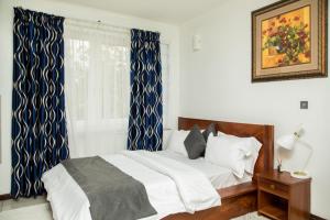 1 dormitorio con 1 cama con cortinas azules y blancas en Ridge Cozy Rooms en Accra