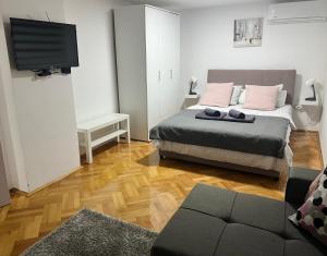 a bedroom with a bed and a flat screen tv at Lily in Belgrade