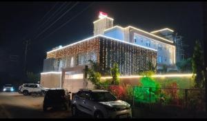 un hotel con coches aparcados delante de él por la noche en Shivhari Hotel & Resort, en Gwalior