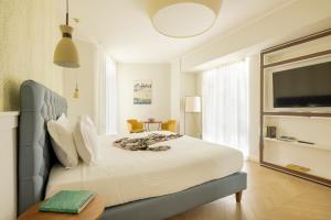 Un dormitorio con una gran cama blanca y una mesa en BeSUITE Apartments, en San Benedetto del Tronto