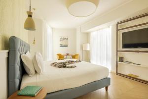 a bedroom with a large white bed and a table at BeSUITE Apartments in San Benedetto del Tronto +52 photos