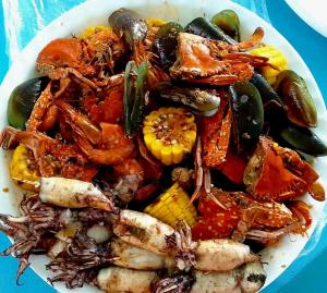 een bord met vis en groenten op een tafel bij HAVEN BREEZE RESORT - A home of Hundred Islands in Alaminos