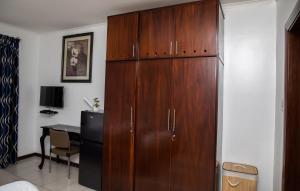 un gran armario de madera en una habitación con escritorio en Ridge Cozy Rooms en Accra