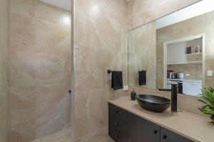 a bathroom with a sink and a mirror at Baligara - Luxury Guest Suite in Bargara