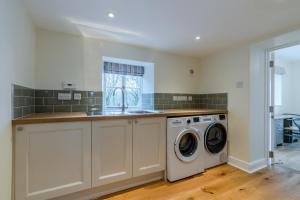 a kitchen with a washing machine and a sink at Deer Park Farmhouse in Lydney +17 photos