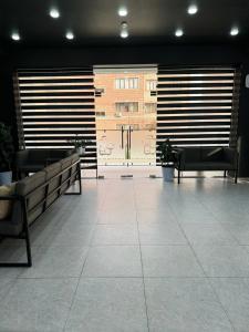 タシュケントにあるSafarov's Family Hostelのベンチ付きのロビー、建物のある大きな窓