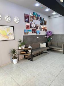 a waiting room with a couch and clocks on the wall at Safarov's Family Hostel in Tashkent