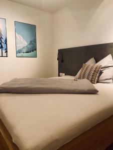 a bed in a bedroom with two pictures on the wall at Alpenchalet zurHinterochsenweide SKI IN & SKI OUT in Brixen im Thale