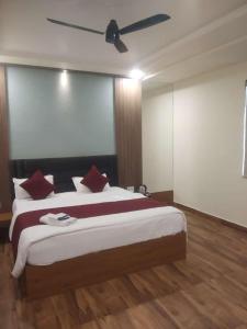 1 dormitorio con 1 cama grande y ventilador de techo en Shivhari Hotel & Resort, en Gwalior