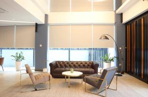 a lobby with a leather couch and chairs at CDX RESIDENCE in Phnom Penh