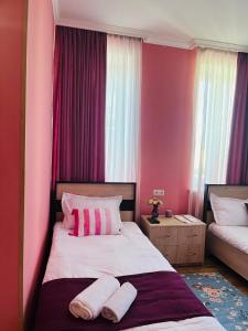 una camera da letto con pareti rosa e un letto con due cuscini di Guest House Lotus a Telavi