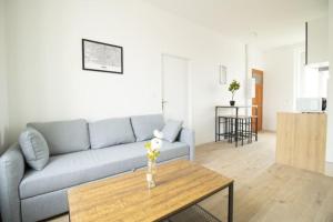 a living room with a couch and a table at Le Logis de la Gare - 4 min à pied de la gare in Bourg-en-Bresse