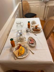 une table blanche avec des assiettes de nourriture dans l'établissement Le manoir de la Cane, à Montfort-sur-Meu