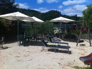 a group of chairs and umbrellas on a beach at Hostal Meson do Loyo in Portomarin