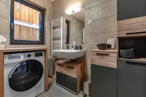 a bathroom with a washing machine and a sink at Apartma Kadulja Golte in Mozirje