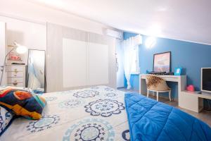 1 dormitorio con paredes azules, 1 cama y escritorio en Parma Elegant and Sweet Apartments, en Parma