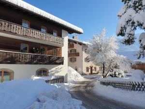 a building covered in snow next to a street at Haus Sabine Fewo Bergliebe in Wallgau