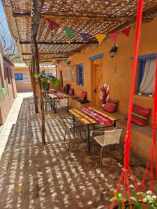 een terras met een tafel en stoelen onder een dak bij Hostal Likancabur in San Pedro de Atacama