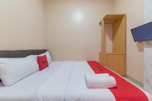 Postel nebo postele na pokoji v ubytování RedDoorz Syariah near Exit Toll Subang